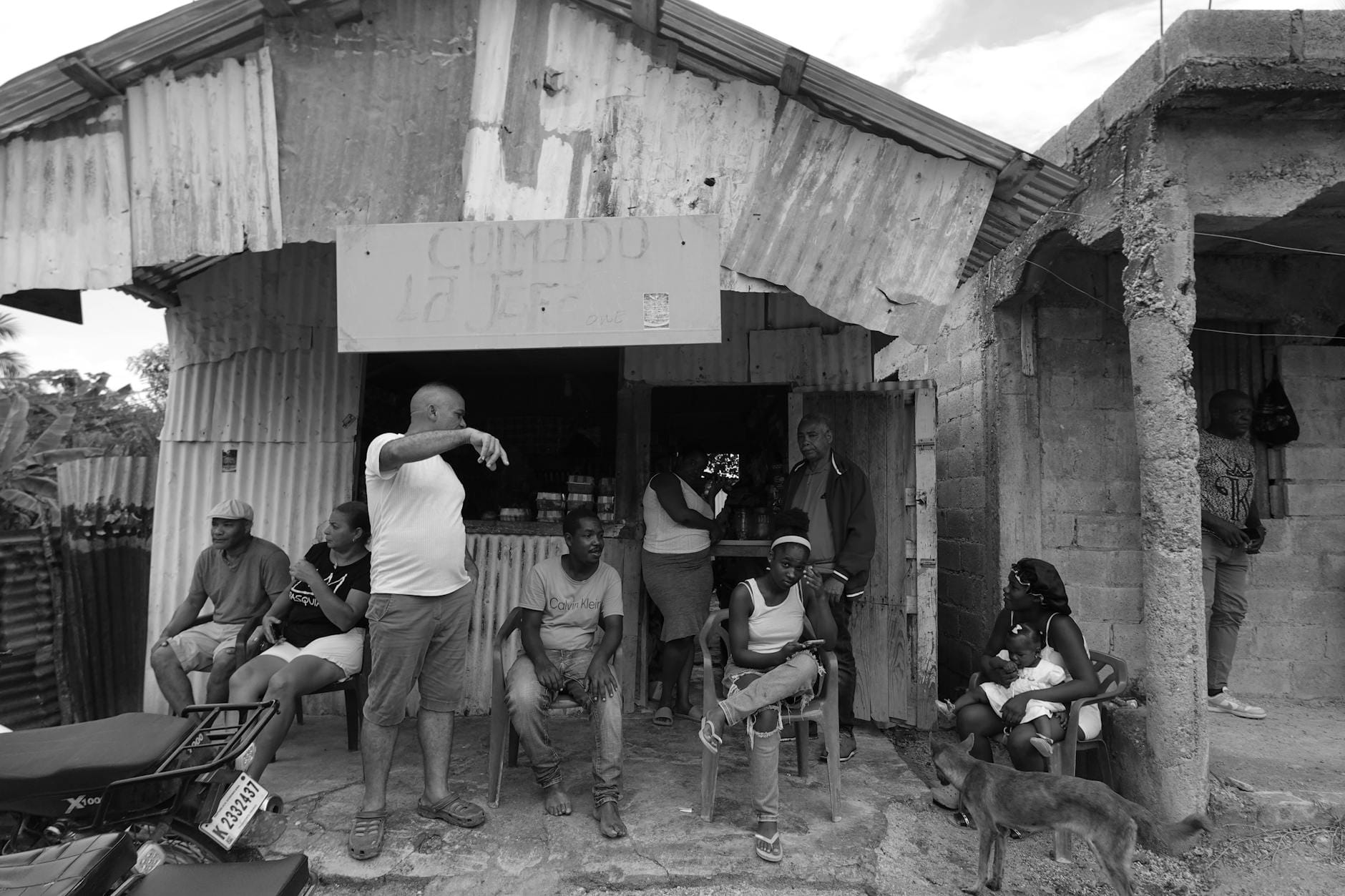 Mieszkańcy przed wiejskim sklepem spotykają się i rozmawiają